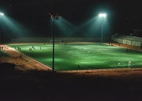 Youth football match under floodlights